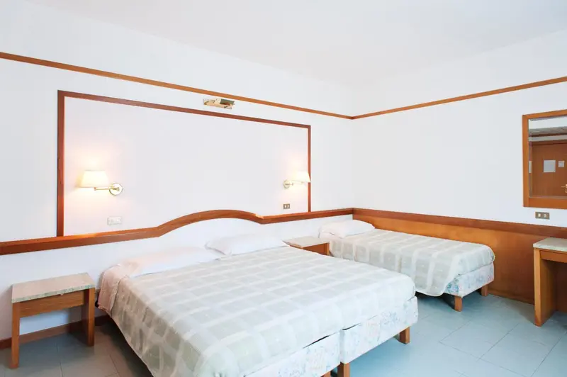 Une chambre lumineuse avec deux lits simples et des tables de chevet.