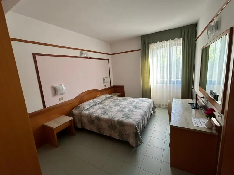 Une chambre d'hôtel avec un lit double et une commode.