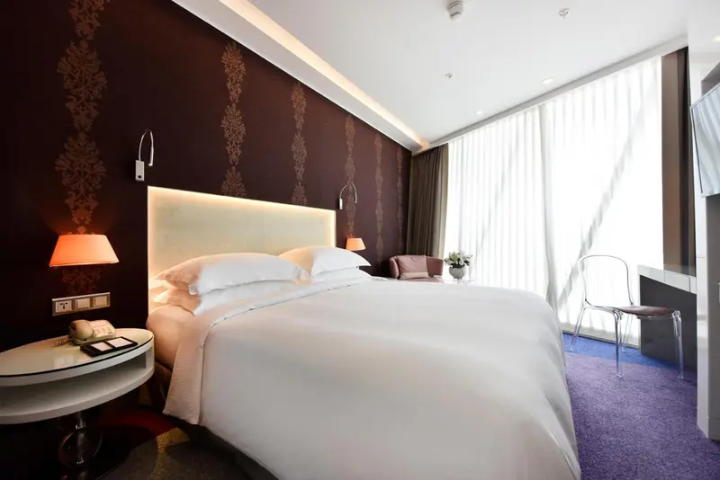 Une chambre lumineuse avec un grand lit et une décoration moderne.