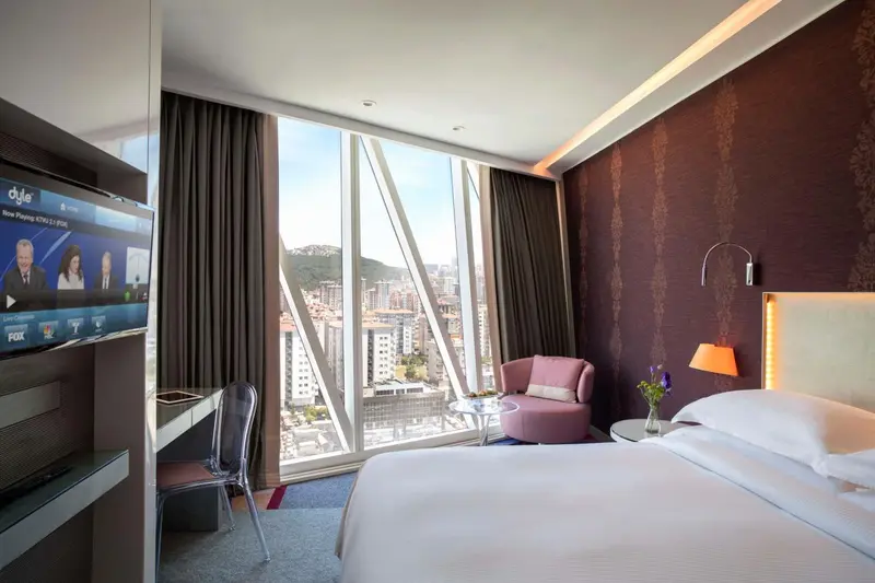 Une chambre moderne avec un grand lit et une vue sur la ville.