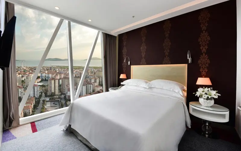 Une chambre moderne avec un grand lit et une vue sur la ville.