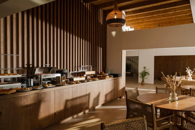 Un buffet propose une variété de plats dans un espace lumineux et décoré de bois.