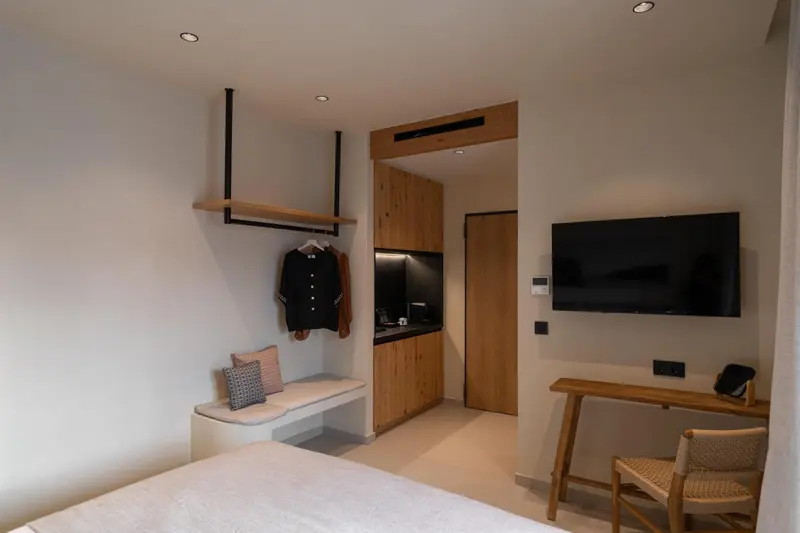 Une chambre lumineuse avec un espace bureau et une kitchenette.