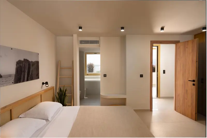 Une chambre lumineuse avec un lit simple et un accès à une salle de bain.