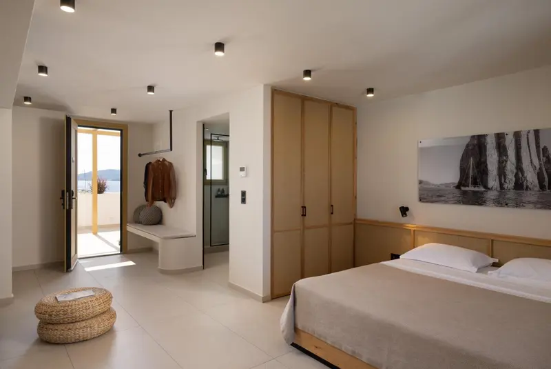 Une chambre lumineuse avec un grand lit et un accès à une terrasse.