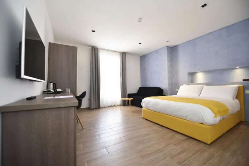 Une chambre lumineuse avec un grand lit et un espace bureau.