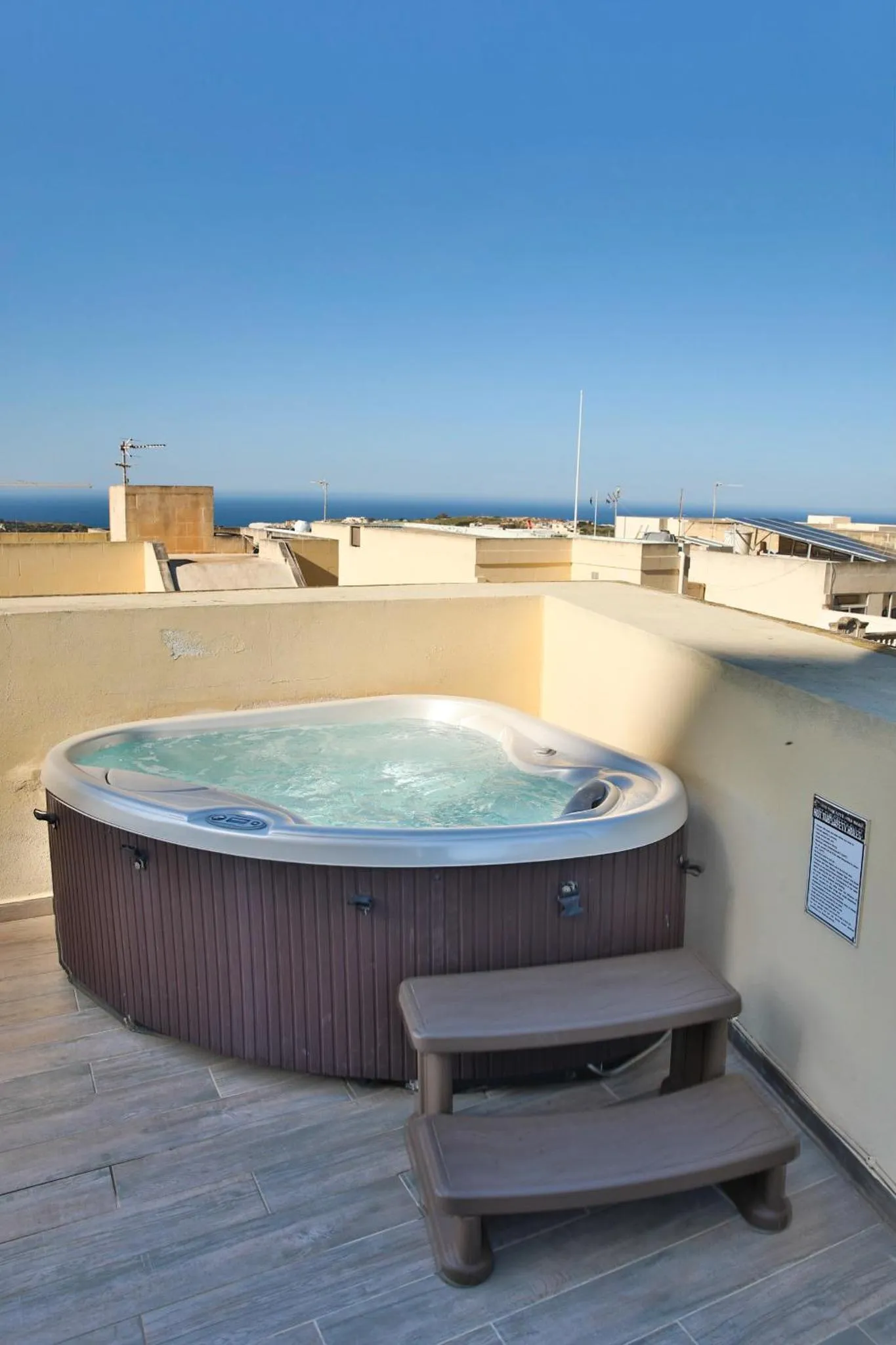 Un jacuzzi sur une terrasse avec vue sur la mer.