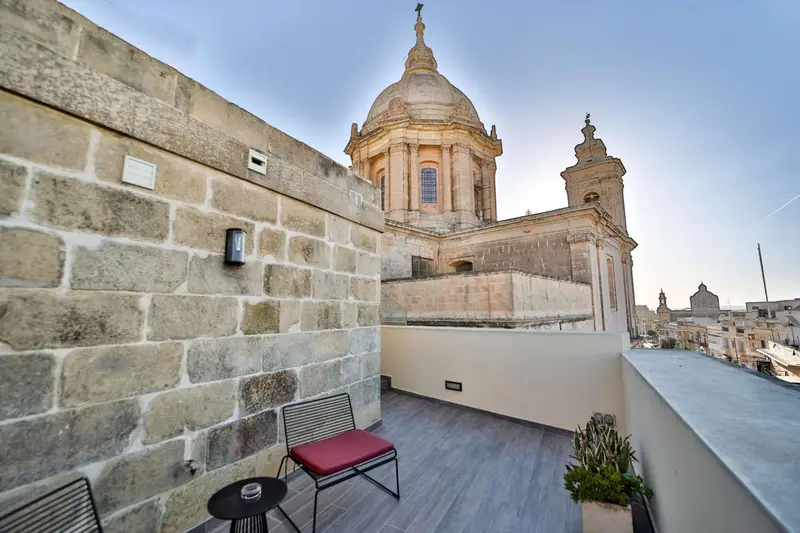 Terrasse avec mobilier d'extérieur et vue sur une église.