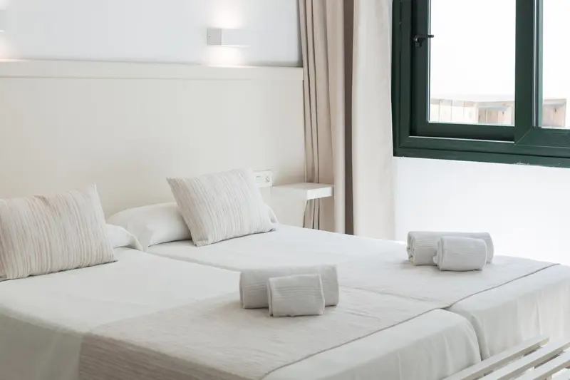 Une chambre lumineuse avec un lit double et des oreillers moelleux.