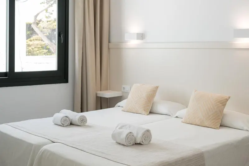 Une chambre lumineuse avec un lit double et des oreillers décorés.