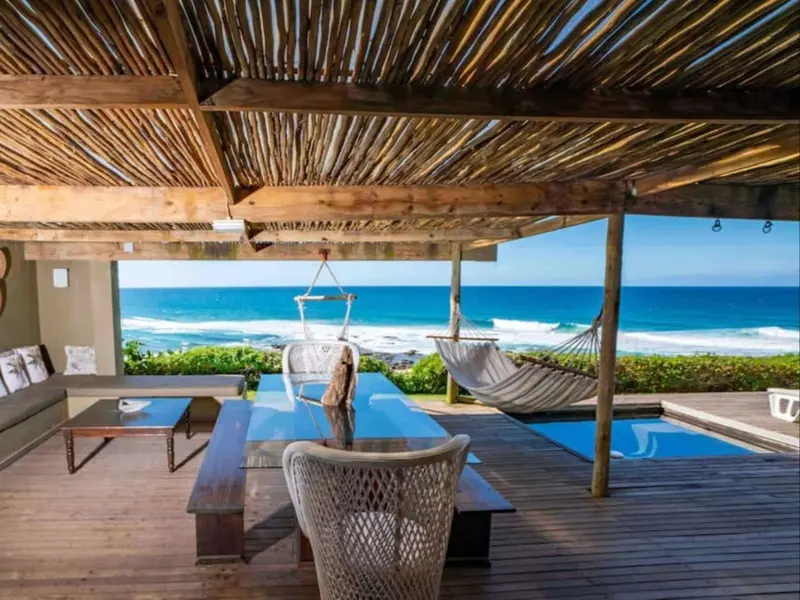 Terrasse en bois avec mobilier d'extérieur et vue sur l'océan.