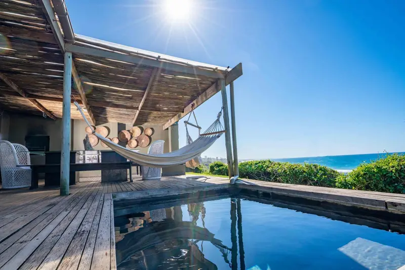 Espace de détente extérieur avec hamacs et petite piscine.