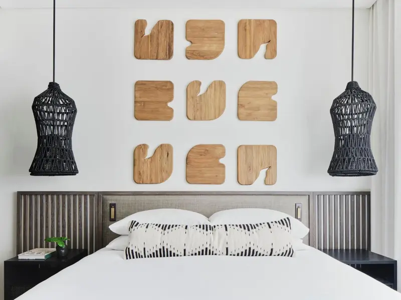 Un lit blanc avec des oreillers décoratifs dans une chambre lumineuse.