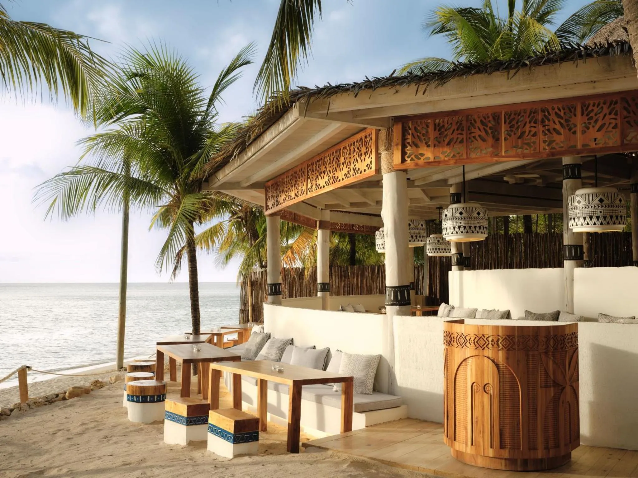 Terrasse ombragée avec mobilier de détente face à la mer.