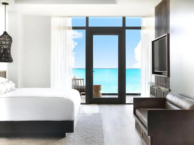 Une chambre lumineuse avec un grand lit et une vue sur la mer.