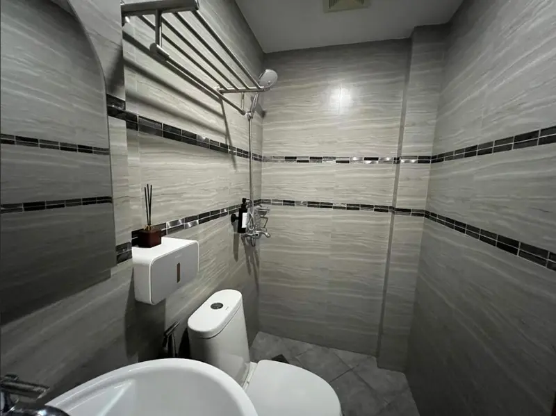 Une salle de bain moderne avec douche à l'italienne et carrelage gris.