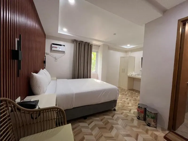 Une chambre lumineuse avec un grand lit et un coin salon.