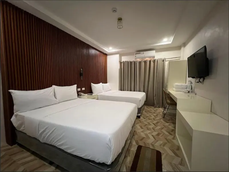 Une chambre avec deux lits simples et un bureau.