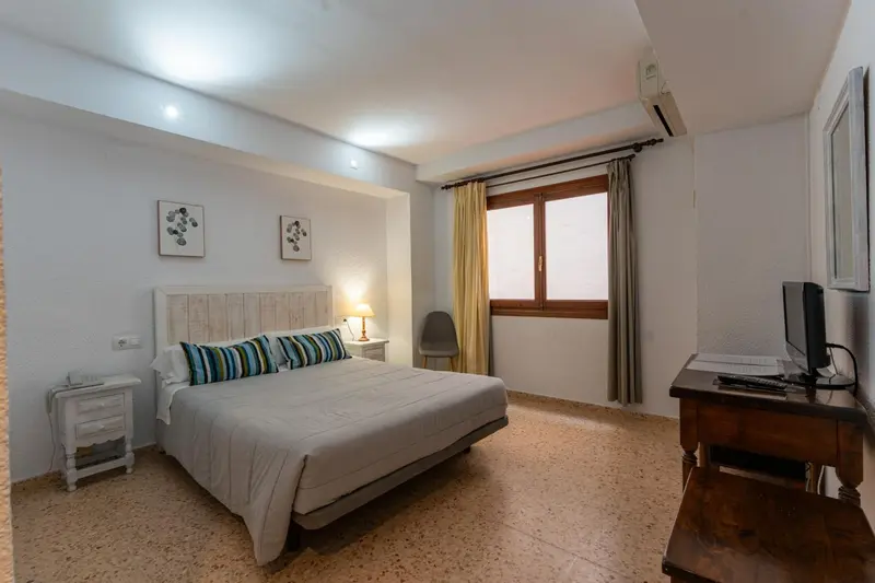 Une chambre lumineuse avec un grand lit et une fenêtre.