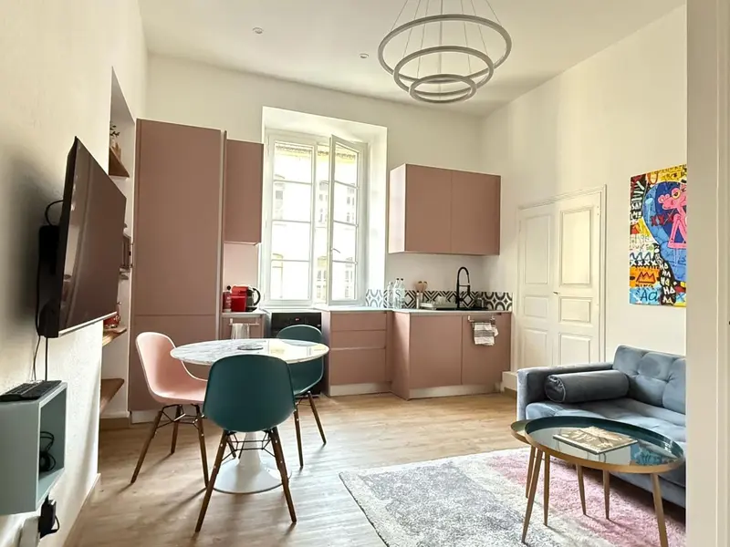Une pièce de vie combine un coin repas et un espace détente avec canapé et télévision.