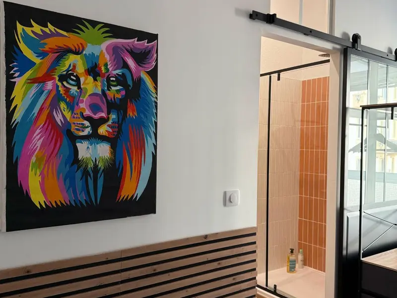 Une décoration murale colorée orne le mur d'une salle de bain moderne.