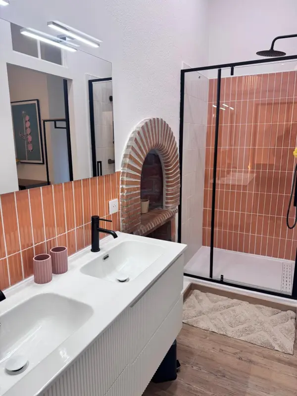 Une salle de bain moderne avec douche à l'italienne et carrelage orange.