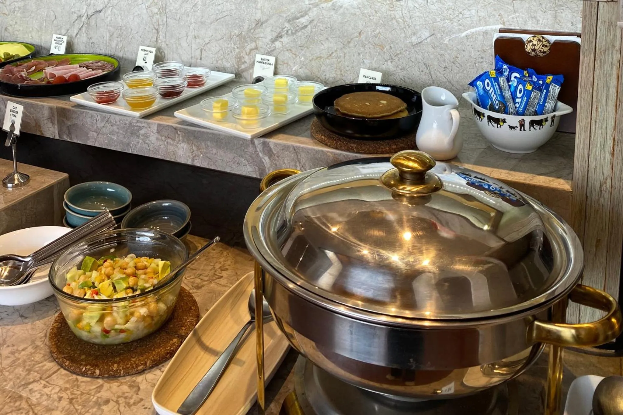 Un buffet propose des pâtisseries, des fruits et des céréales.