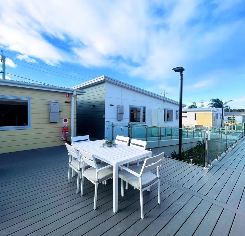 Terrasse aménagée avec table et chaises devant des bâtiments modernes.