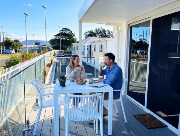 Un couple prend son petit-déjeuner sur une terrasse ensoleillée.