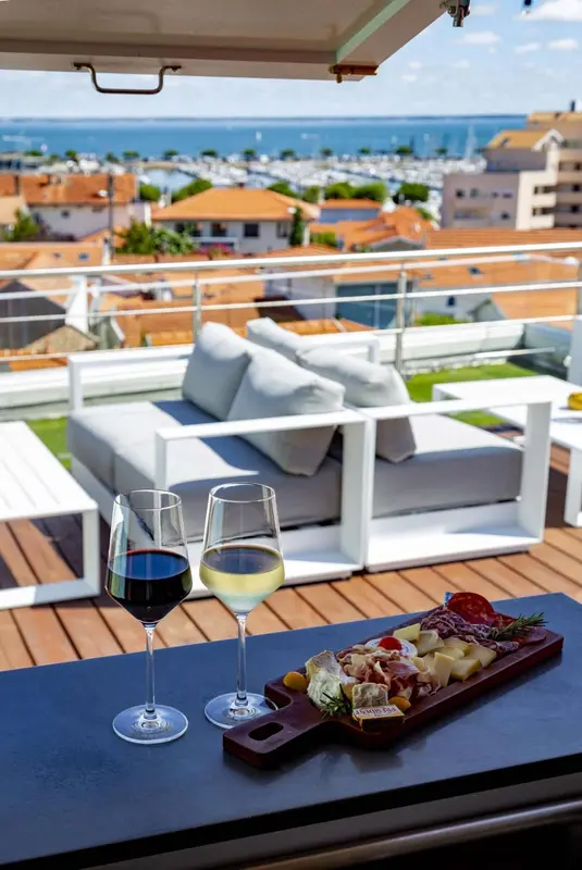Une terrasse aménagée avec des canapés, une table basse et des boissons.