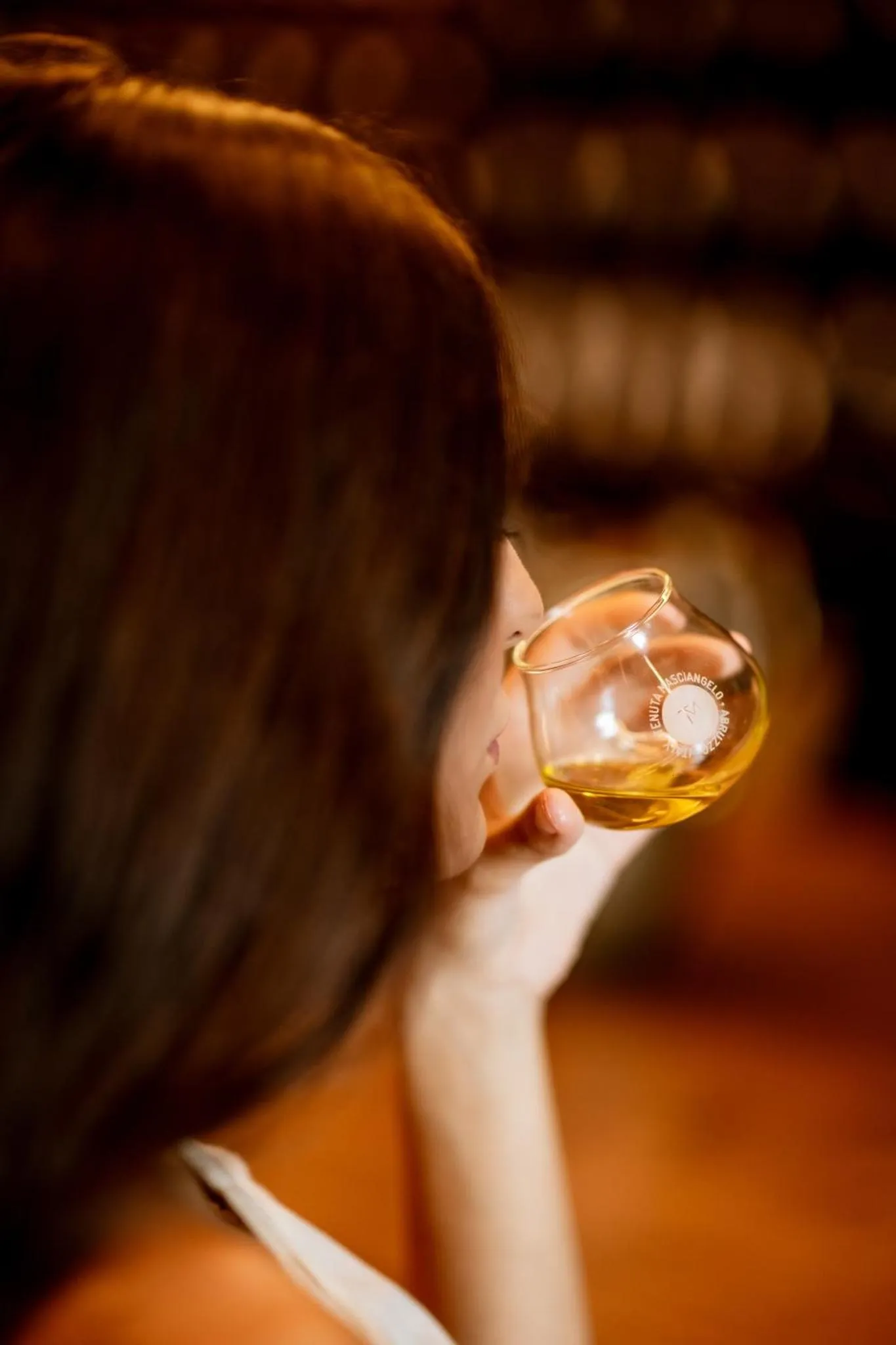 Une personne déguste une boisson dans un verre.