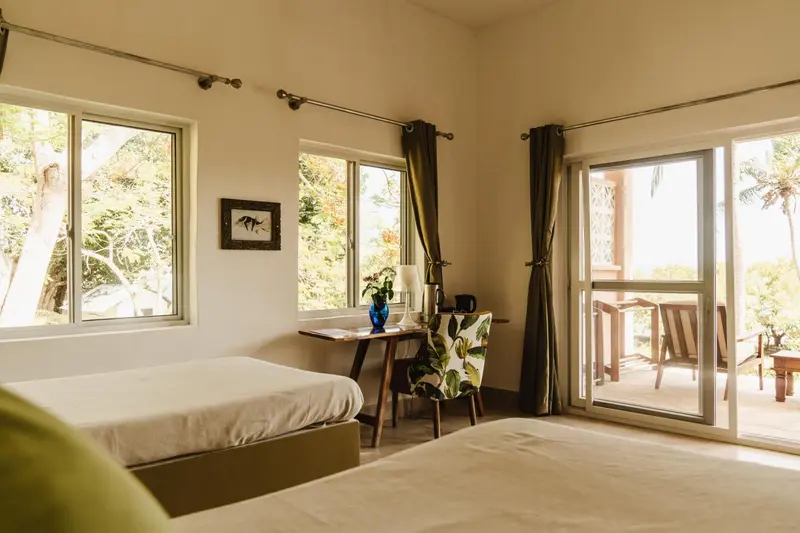 Une chambre lumineuse avec un bureau et un accès à une terrasse.