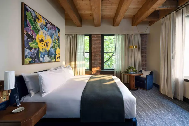 Une chambre lumineuse avec un grand lit et une décoration florale.
