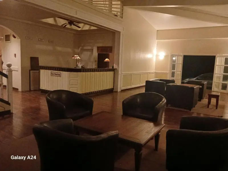 Un hall d'accueil lumineux avec un comptoir et des fauteuils.
