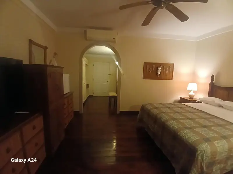 Une chambre à coucher avec un lit et une commode en bois.