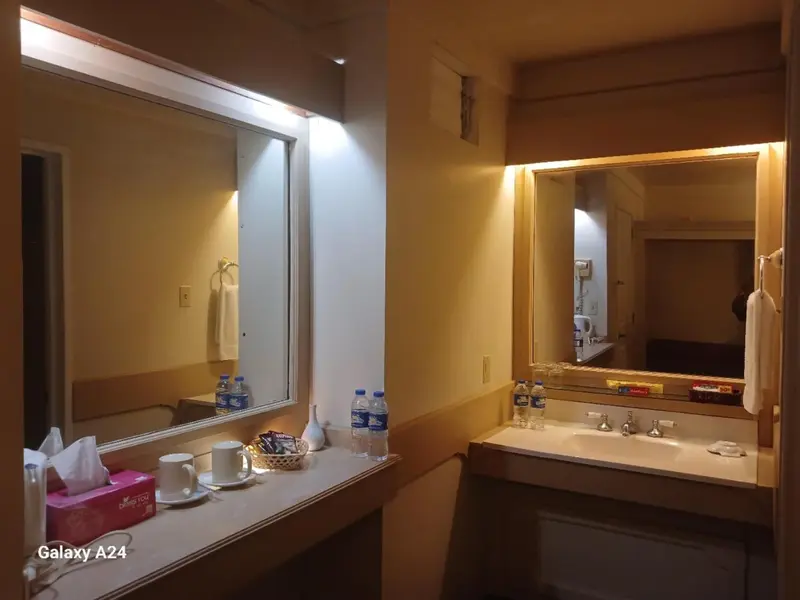 Une salle de bain avec un grand miroir et un comptoir.