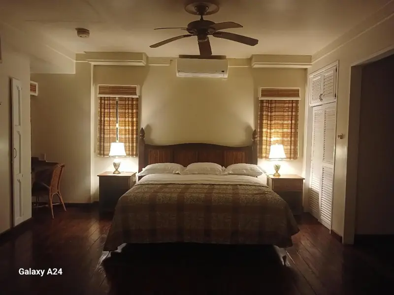 Une chambre lumineuse avec un grand lit et des meubles en bois.