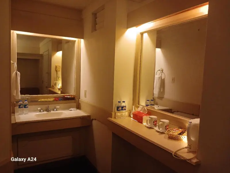 Une salle de bain avec des lavabos, des miroirs et des serviettes.