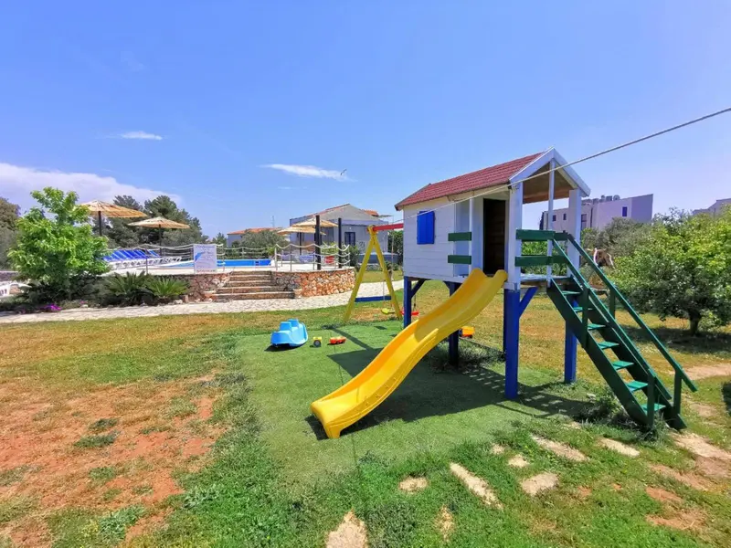 Aire de jeux colorée avec toboggan et structure en bois sur pelouse.