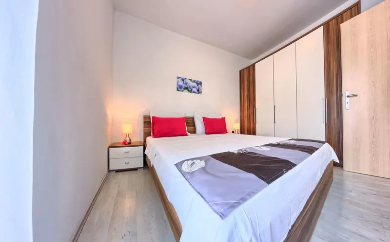 Une chambre lumineuse avec un grand lit et des rangements.