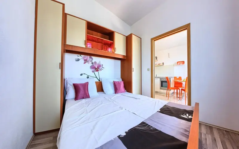 Une chambre avec un lit double et des rangements intégrés.