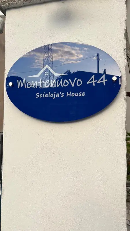 Plaque bleue avec le nom d'un établissement et une illustration d'une maison.