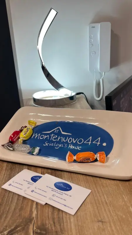 Un plateau de bienvenue avec des chocolats et des informations sur l'établissement est posé sur un meuble en bois.