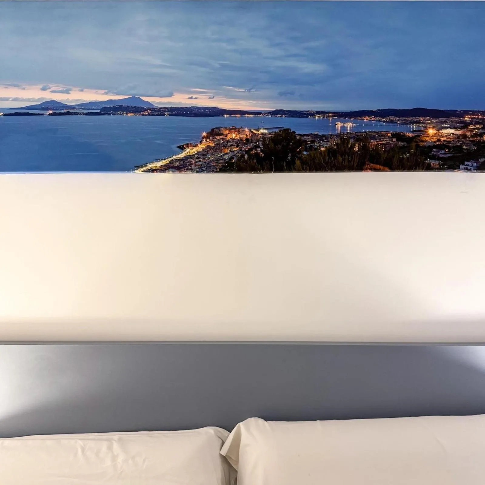 Vue panoramique sur la mer et la côte illuminée au crépuscule.