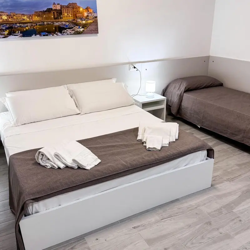 Une chambre avec deux lits et une vue sur un port.