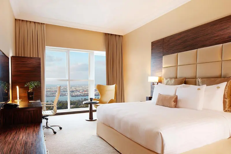 Chambre lumineuse avec un grand lit et une vue sur la mer.