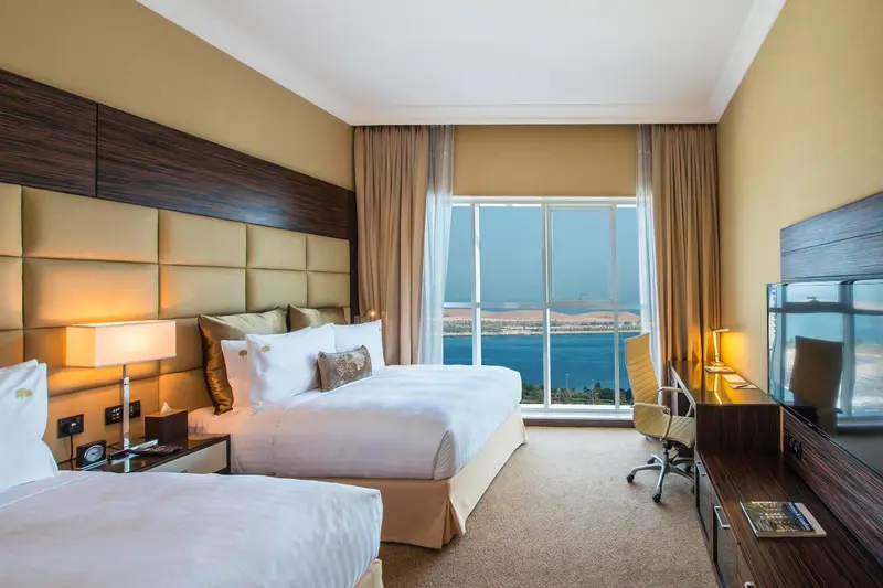 Une chambre lumineuse avec un grand lit et une vue sur la mer.