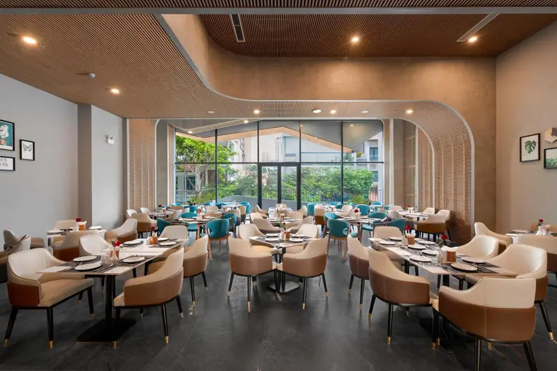 Une salle de restaurant lumineuse avec des tables dressées et des chaises confortables.