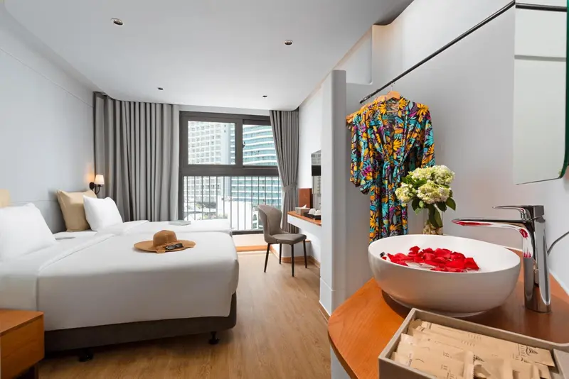 Chambre lumineuse avec un grand lit et une baignoire moderne.