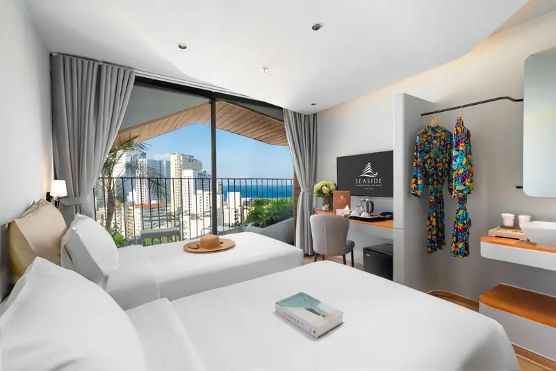 Chambre lumineuse avec un grand lit et une vue sur la mer.